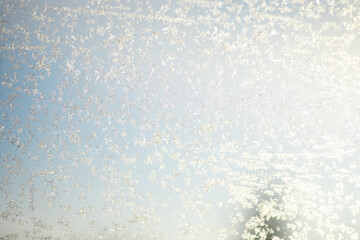 Close-up of Frosted Window with Delicate Snowflakes on a Bright Winter Day