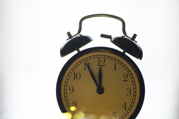 Vintage Analog Alarm Clock Showing Midnight with Backlit Glow on White Background