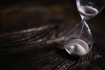 Close-Up of Hourglass on Dark Wooden Surface Symbolizing Time Passing, Business Deadlines, and...