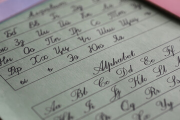 ** Close-up of Cursive Alphabet on Light Green Paper for Language Learning and Calligraphy