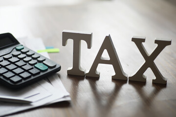Tax Preparation Concept with Calculator and Documents on Wooden Desk