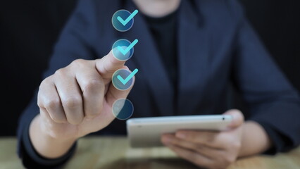 Businessman touching to screen of smartphone to tick correct mark to approve document and project concept.