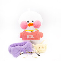 Soft children's toy white duck with a bag and glasses. Isolated object on a white background.
