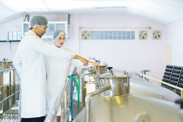 Quality control officer are examining in beverage manufacturing factory.