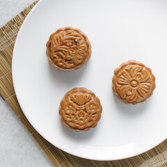 Overhead view of homemade mooncakes, top view of baked mooncakes on white plate, process of making mooncakes for Lunar New Year and mid autumn festival