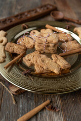 Spekulatius cookies fresh and homemade baked on a golden christmas plate on wooden table background