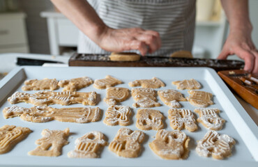 Woman preparing and baking christmas cookies, german spekulatius in the kitchen