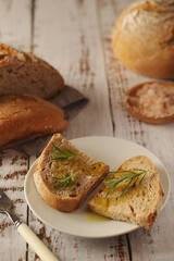 A loaf of rye bread with oil and rosemary in rustic style