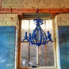 Blue chandelier against brick wall