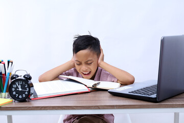 Stressed asian schoolboy gesture studying in classroom while covering ears. Isolated on white...