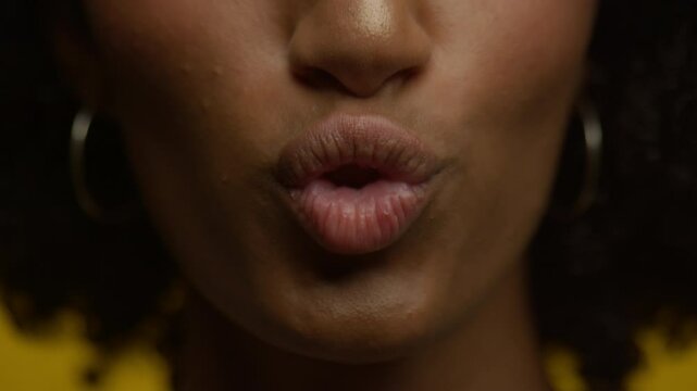Close-up of Puckered Lips Against Yellow Background