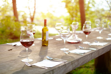 wine glasses on a wooden table in the countryside shallow depth of field
