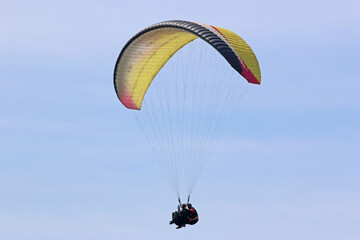 Tandem Paraglider flying in a cloudy sky	