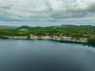 Fototapeta premium Aerial drone of mining quarry with flooded bottom. Lake with blue water near sand pit. Sipalay, Negros, Philippines.