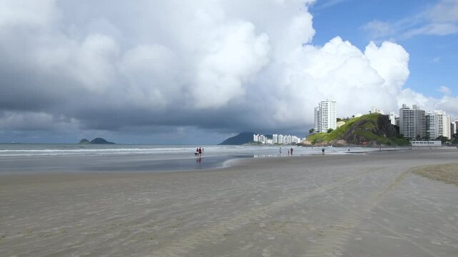 Morning at Enseada Beach on cloudy morning, view to the beach sand, the sea and the hills on background. Guaruja - SP, Brazil.