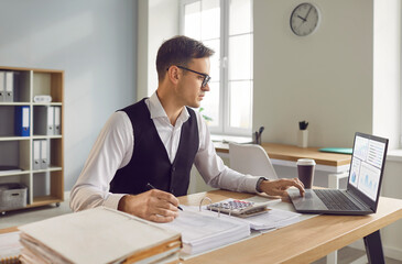 Portrait of a focused businessman accountant works in the office or at home office, seated at a...
