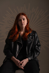 Studio portrait of a young beautiful red-haired girl.