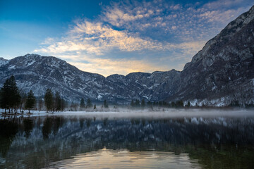 Fototapeta premium Berge spiegeln sich bei Sonnenuntergang im See, Bohinj See, Slowenien