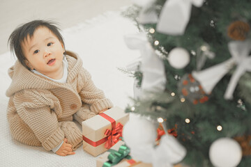 Adorable Baby in White Outfit Lying on a Soft Blanket with Gift Boxes