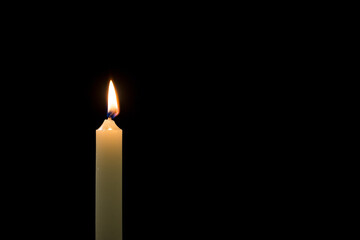 White candle on a black background, close up shot. Memory, symbol, religion, and prayer concepts.
