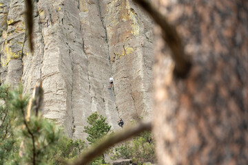 Two people climbing a rock wall on Devils Tower