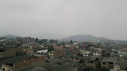 Aerial view of a large urban landscape of an impoverished town on a sunny but cloudy day captured by a drone