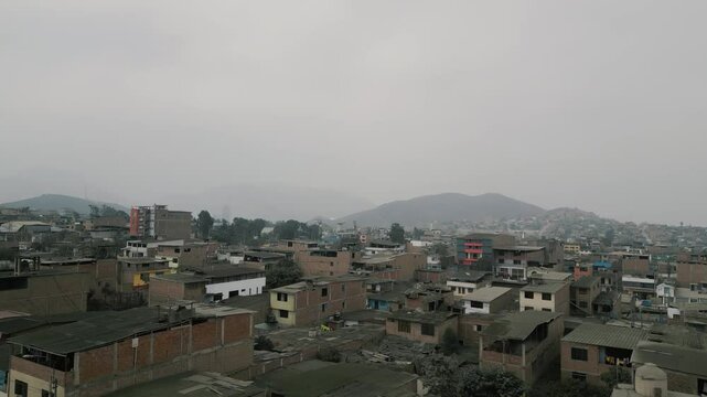Aerial view of a large urban landscape of an impoverished town on a sunny but cloudy day captured by a drone