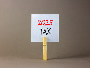 Planning 2025 tax new year symbol. Concept words 2025 Tax on beautiful white paper on wooden clothespin. Beautiful grey background. Business 2025 tax new year concept. Copy space.