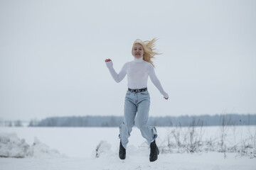 Portrait of young beautiful blonde girl outdoors in winter.