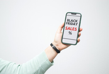 Female hand holding a smartphone with screen displaying a Black Friday online sale