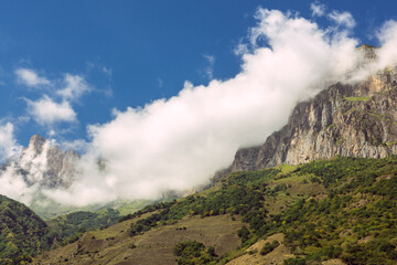 Caucasus, green mountains. View on the enchanting hills and blue sky with white cottony clouds