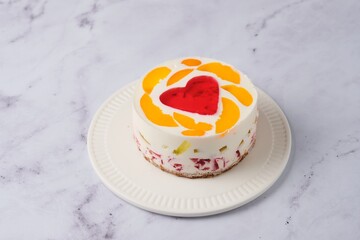 Jelly cake with red heart center on white plate on light marble background. Valentine's Day desserts. Valentine's Day.