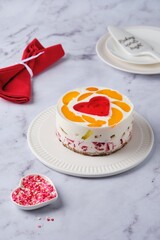 Jelly cake with red heart center on white plate on light marble background. Valentine's Day desserts. Valentine's Day.