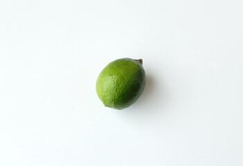 Single green lime on white background. Brazilian tropical citrus fruit. Vitamin C rich food, juicy and healthy organic ingredient for vegetarian diet.