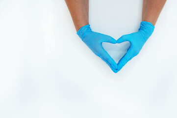 Hands in blue medical gloves folded in the shape of a heart on a white background.