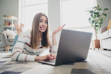 Young woman enjoying a relaxing moment at home with her laptop, smiling in natural daylight