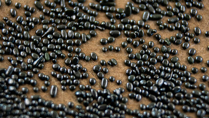 Black smokeless gunpowder: Close up of silver granules of black smokeless gunpowder.