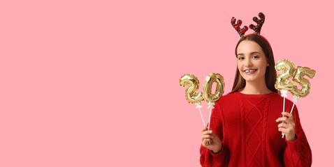 Young woman in sweater, with Christmas reindeer horns and balloons in shape of figure 2025 on pink background with space for text