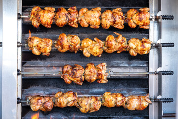 Juicy Golden-Brown Grilled Chickens Rotating on a Market Grill