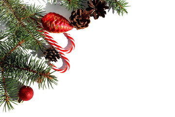 On a white isolated background there are Christmas tree decorations and fir branches.