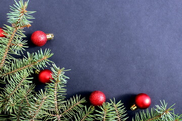 Christmas background with fir branches and toys with space for text on a black background.