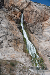 Waterfall Cascading Down Rocks Surrounded by Moss and Formations