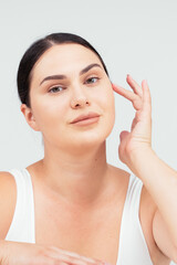 Portrait of a young woman on a white background, symbolizing purity and natural beauty. Perfect for projects related to skincare, health, and wellness.