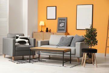 Cozy sofa, armchair and coffee table in interior of living room