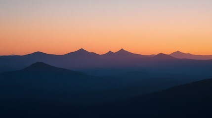 Obraz premium Sunrise over the mountains, with the early morning light illuminating the rugged peaks in a warm, golden glow