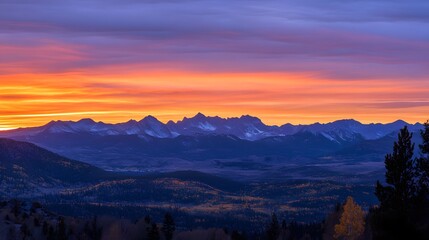 Fototapeta premium Sunrise over the mountains, with the early morning light illuminating the rugged peaks in a warm, golden glow