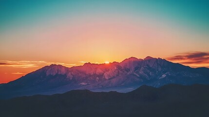 Obraz premium Sunrise over the mountains, with the early morning light illuminating the rugged peaks in a warm, golden glow