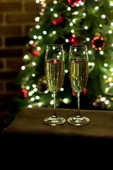 Two glasses of champagne on the background of a Christmas tree. New Year