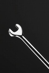 Close-up of a shiny metal wrench on a dark background
