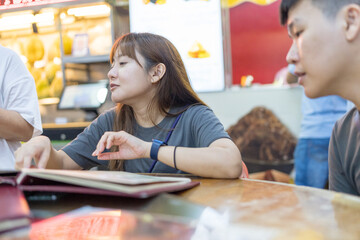 Chinese Malaysian couple in their 35s enjoying meal at famous bak kut teh shop popular with locals in Kuala Lumpur, Malaysia.